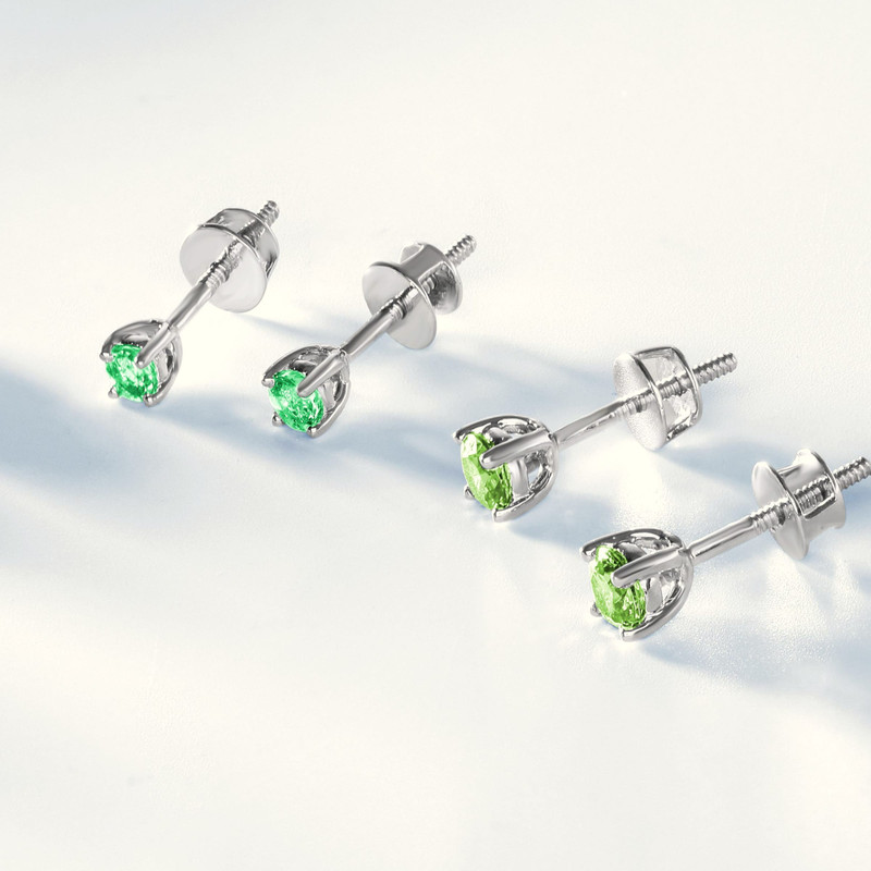 Green-stone solitaire studs in white-metal claws on white (cropped from a multi-colour stud line-up).