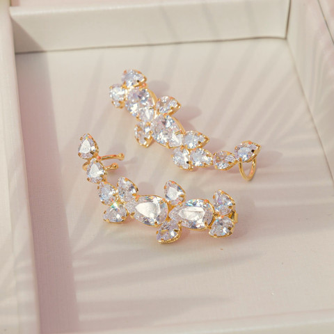 Pair of crystal cluster climber earrings in gold settings inside a white display box with soft shadow.