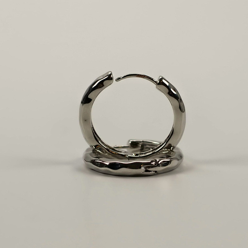 Pair of polished silver hoop earrings on a light grey background.