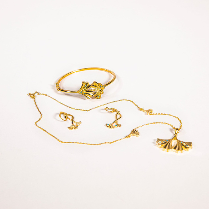 Second arrangement of the same ginkgo-leaf gold set on white.