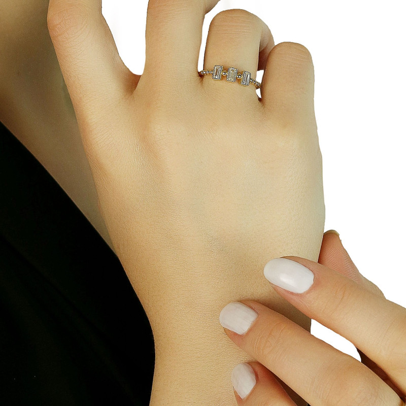 Hand at chin wearing the same gold baguette band, white background.