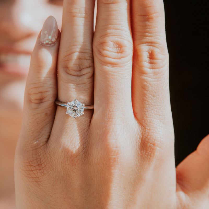 The Aurora Solitaire Ring worn on a hand.